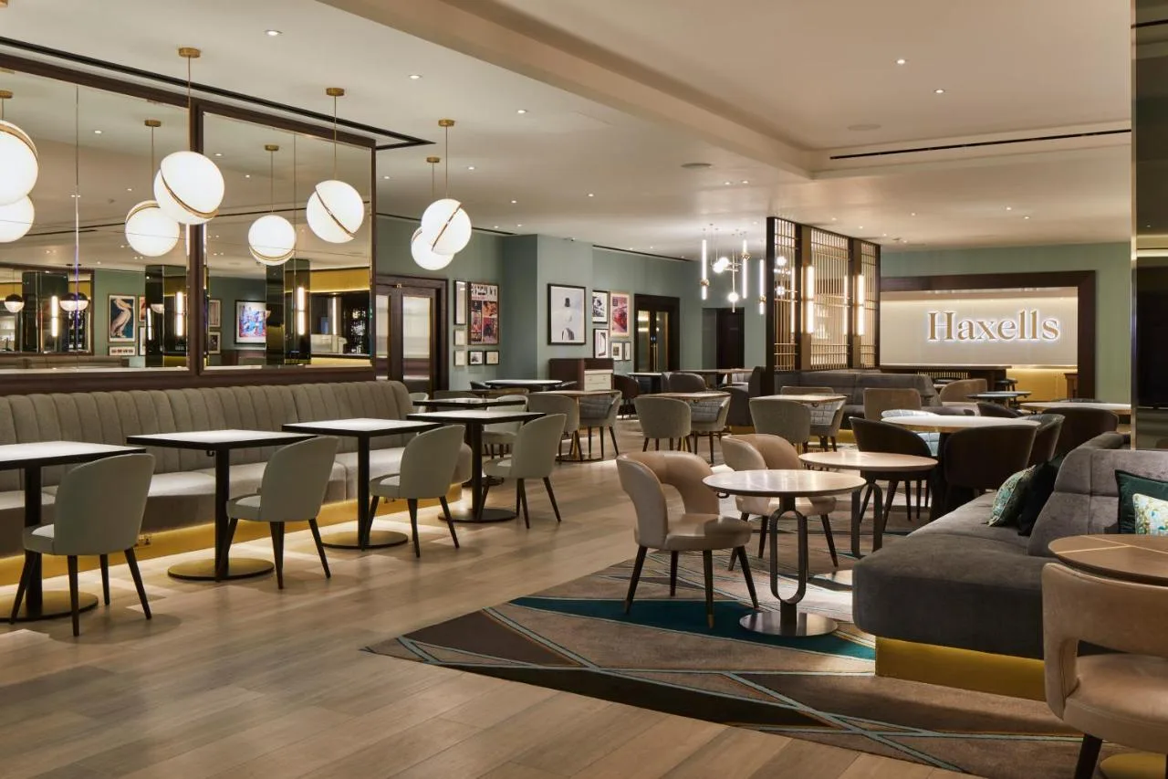 a restaurant with tables and chairs and a lobby at Strand Palace in London